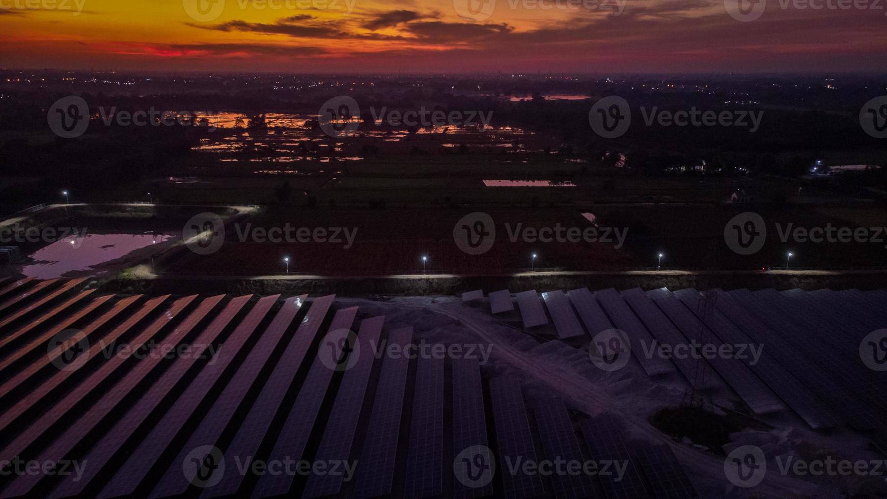 luchtfoto van een zonnepark dat 's avonds met schemering schone energie produceert en rondom zichtbaar is foto