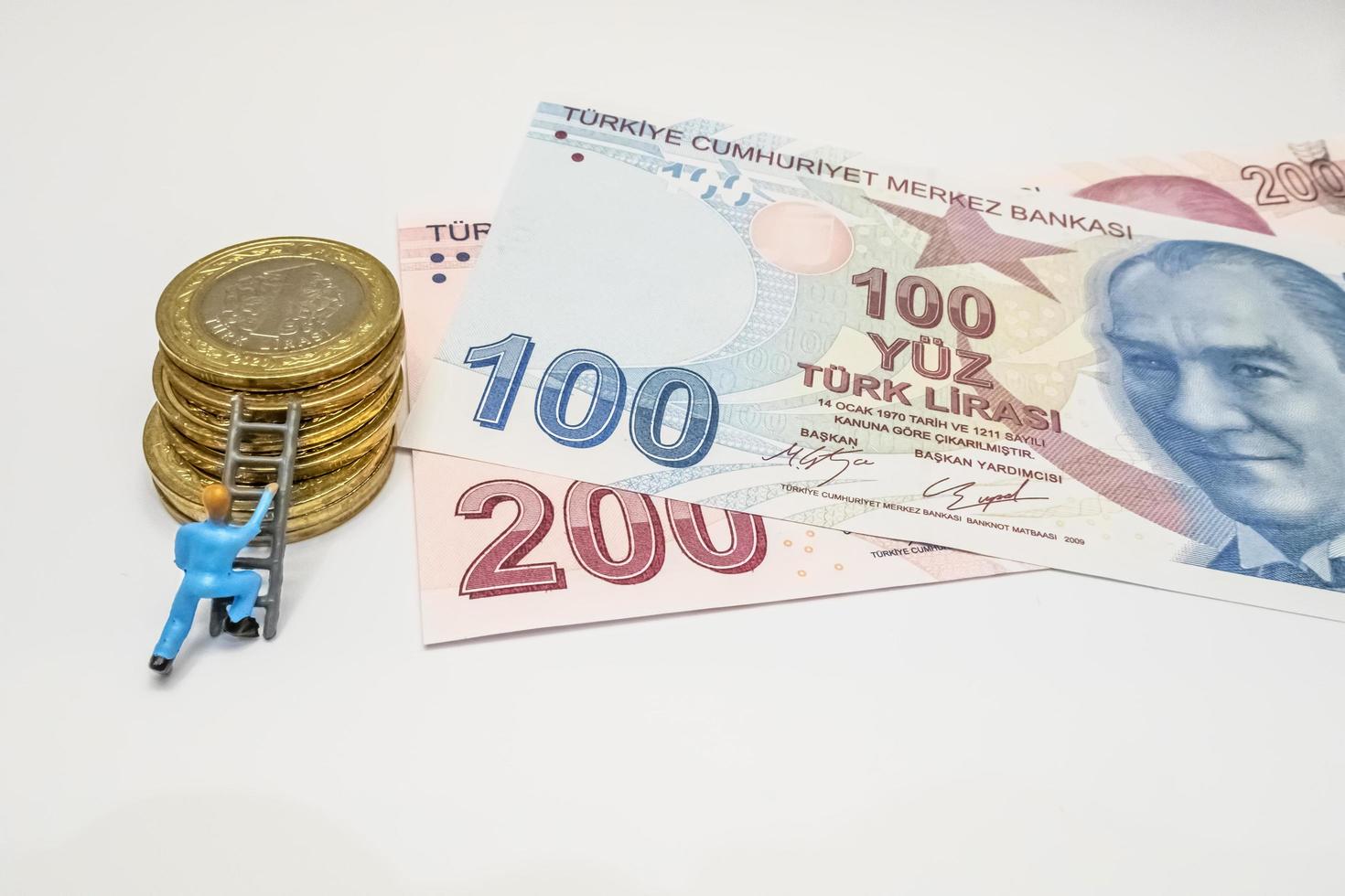 Istanbul, Turkije-december 24,2021. Turkse lira bankbiljetten, munten en miniatuur werknemer op een witte achtergrond foto