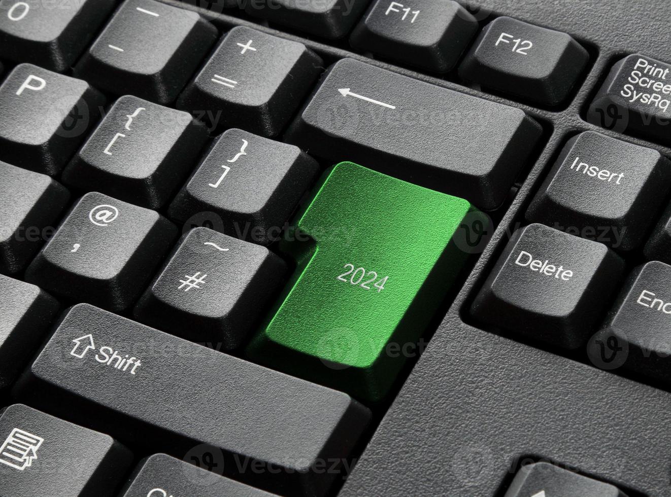 een zwart toetsenbord met groene 2024-toets foto