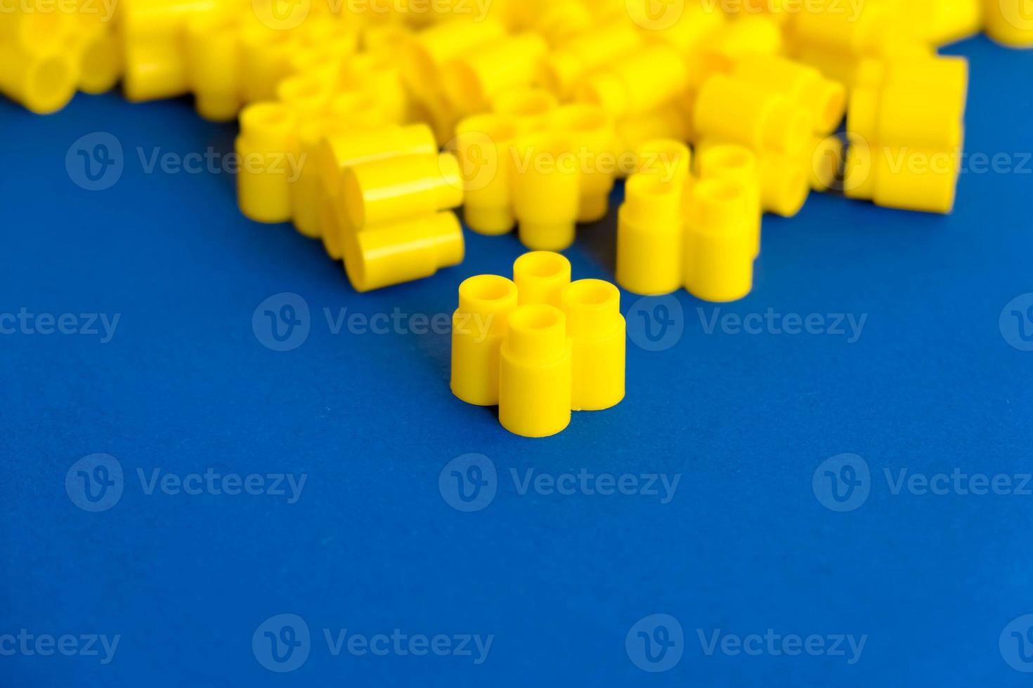 gele plastic bouwstenen op een blauwe achtergrond foto