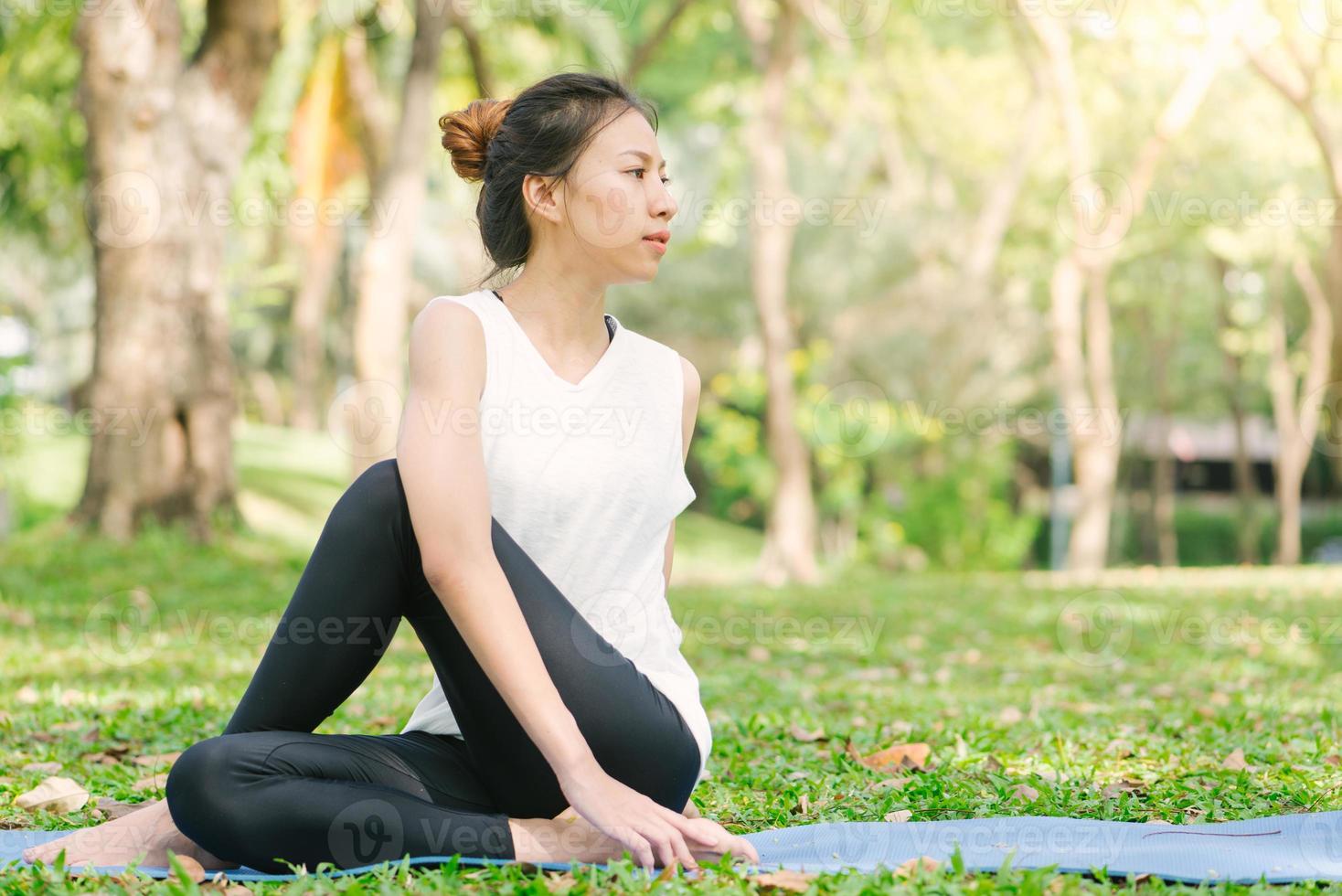 jonge Aziatische vrouw yoga buitenshuis blijf kalm en mediteert tijdens het beoefenen van yoga om de innerlijke rust te verkennen. yoga en meditatie hebben goede voordelen voor de gezondheid. yoga sport en een gezonde levensstijl concept. foto