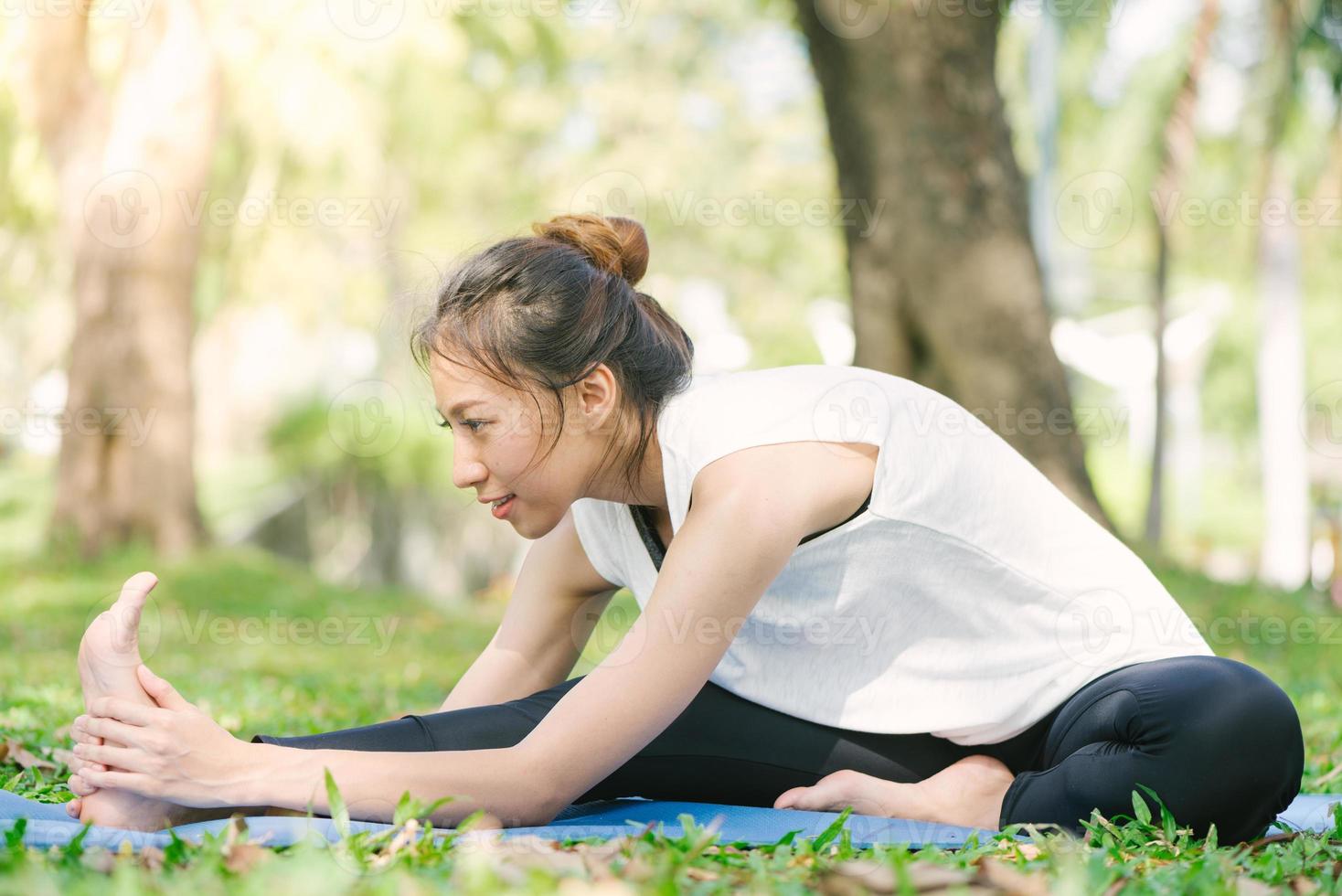 jonge Aziatische vrouw yoga buitenshuis blijf kalm en mediteert tijdens het beoefenen van yoga om de innerlijke rust te verkennen. yoga en meditatie hebben goede voordelen voor de gezondheid. yoga sport en een gezonde levensstijl concept. foto