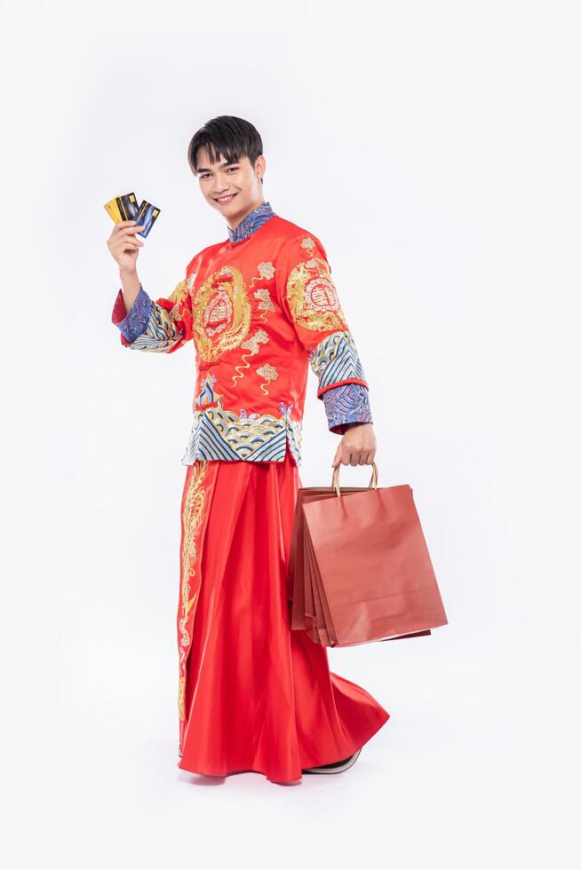 man draagt een cheongsam-pak en haalt veel dingen uit het gebruik van een creditcard in het chinees nieuwjaar foto