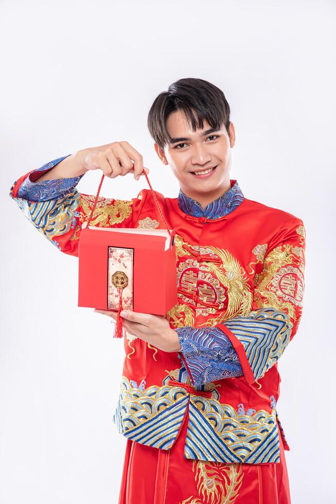 man draagt cheongsam klaar om rode tas aan zus te geven voor verrassing op traditionele dag foto