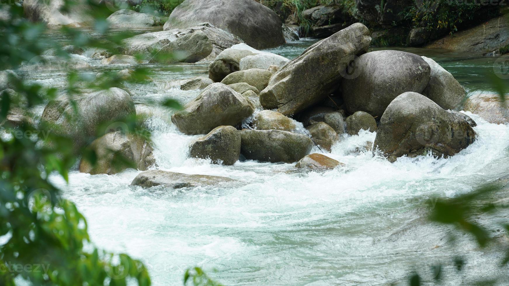 het prachtige uitzicht op het platteland met de waterval die in de bergen stroomt na de regenachtige dag foto