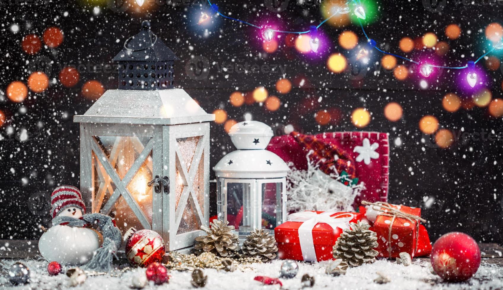 kerstlantaarn op besneeuwde tafel met feestelijke decoratie. foto