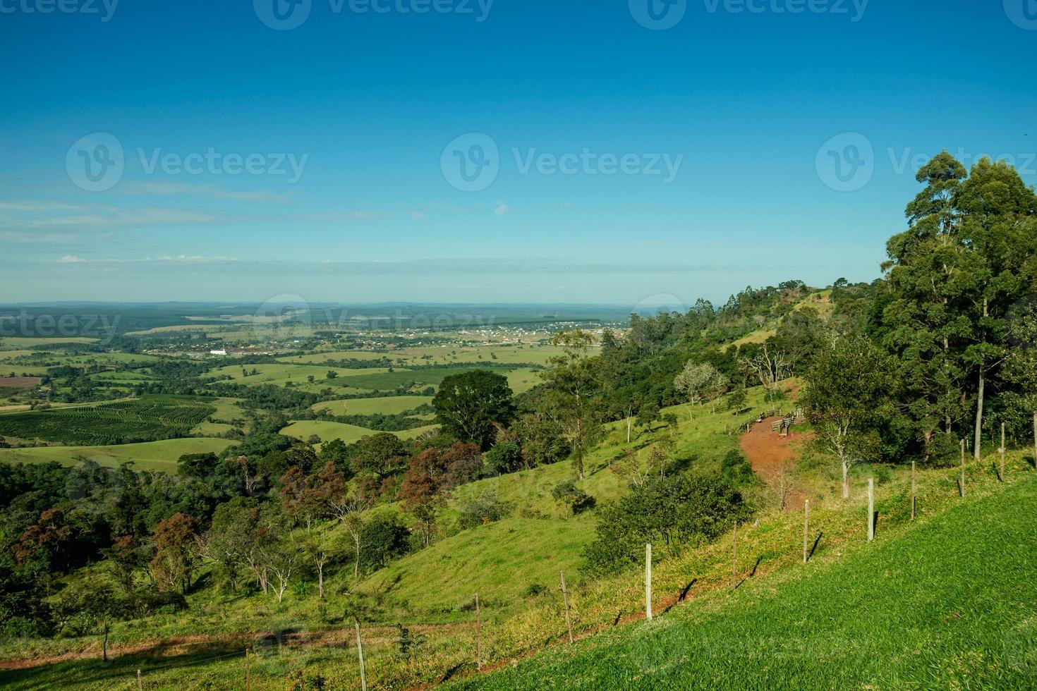 groene brede vallei in een heuvelachtig landschap bedekt met bos en weide op een zonnige dag in de buurt van pardinho. een klein landelijk dorp op het platteland van de staat Sao Paulo. foto