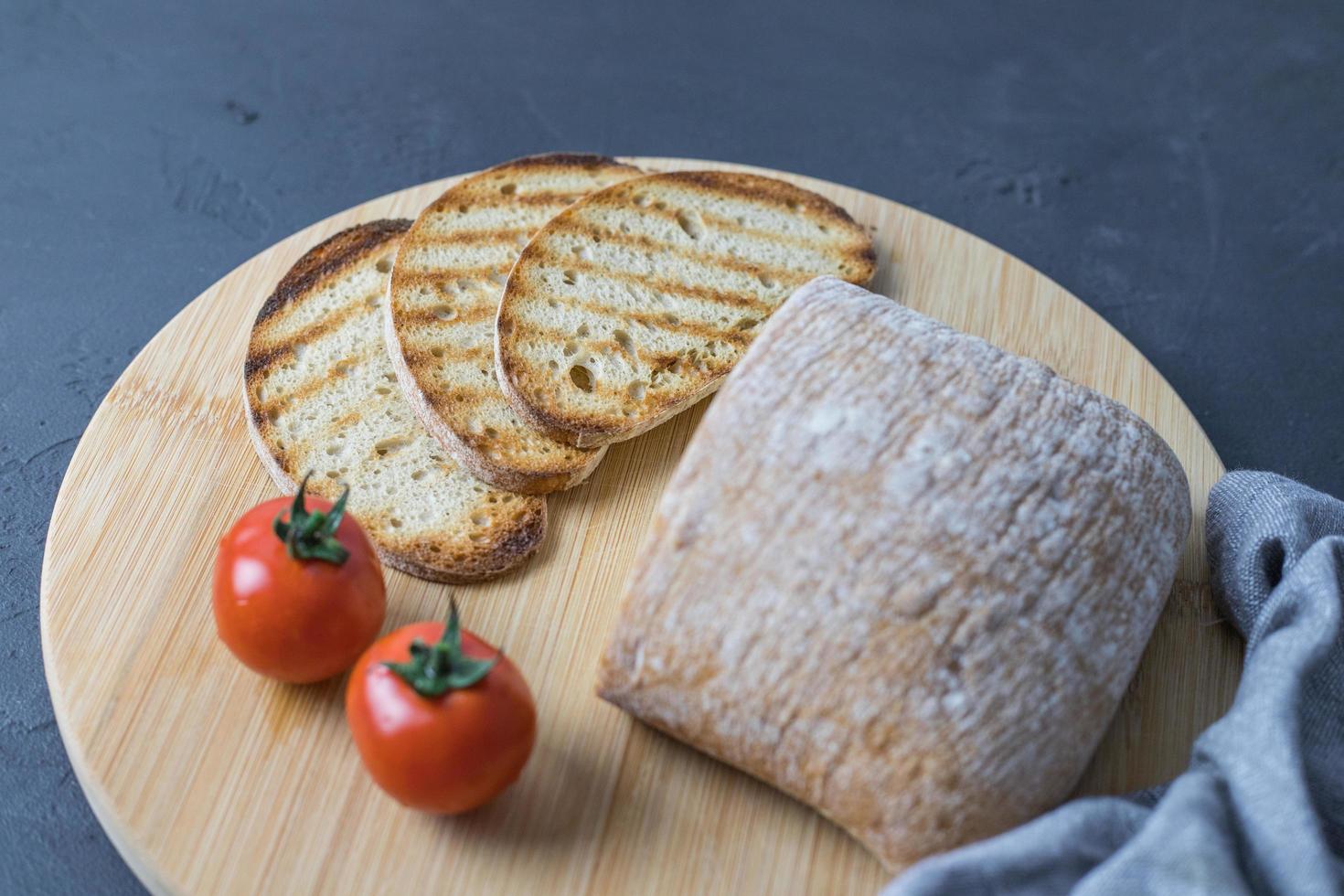 Gegrilde sneetjes brood liggend op een houten keukenplank foto