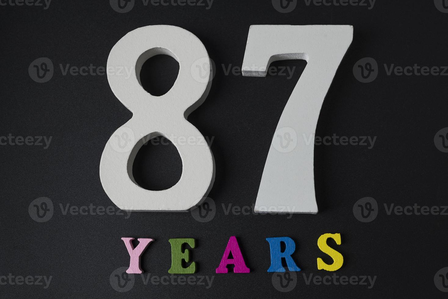 letters en cijfers zevenentachtig jaar oud op een zwarte achtergrond. foto