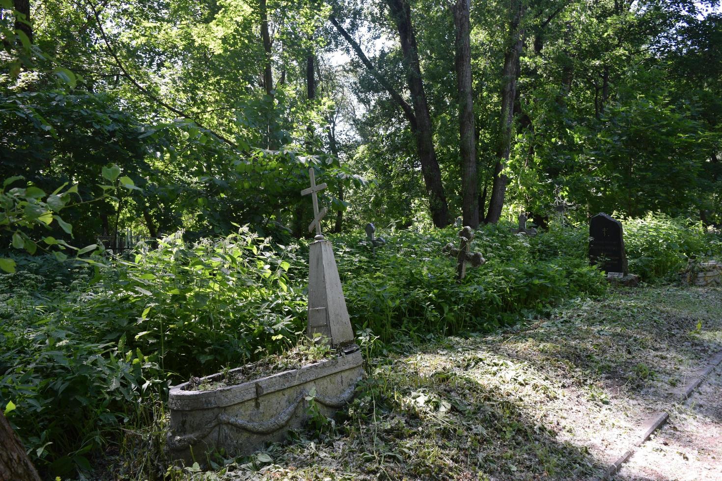 de oude verlaten begraafplaats en overwoekerde graven foto