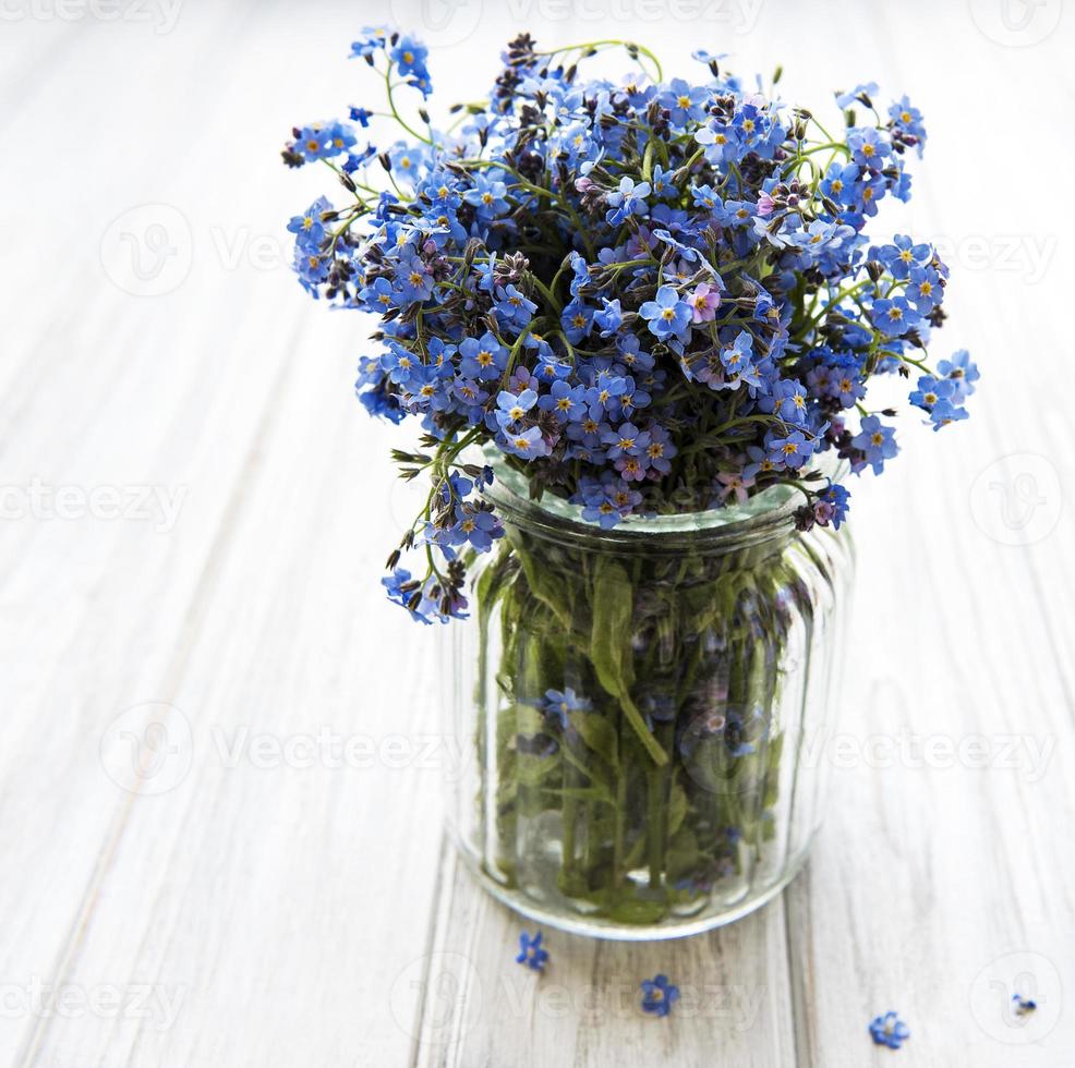 boeket vergeet-mij-niet bloemen in glazen vaas foto