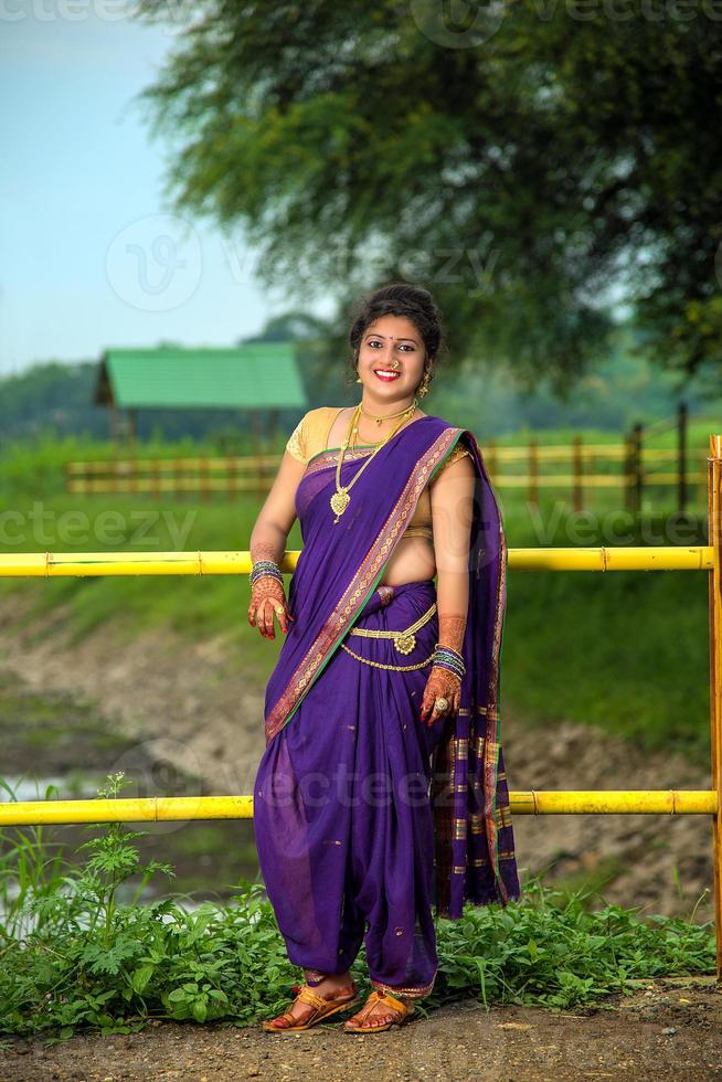 mooi Indisch jong meisje in traditionele saree die buitenshuis poseert foto