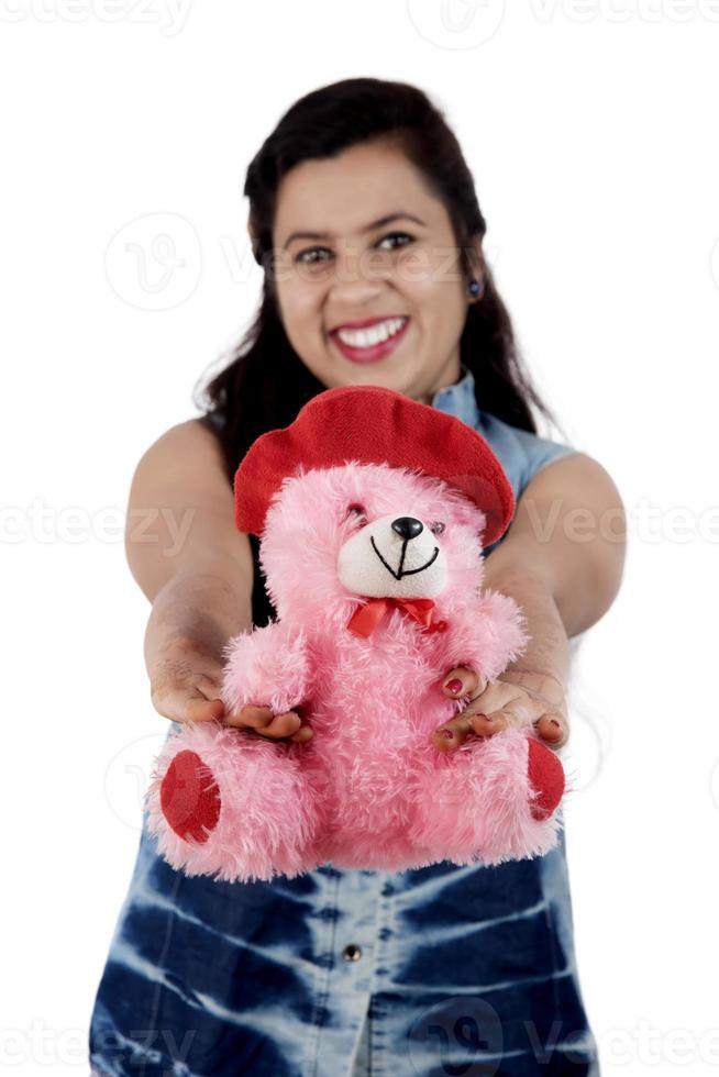 mooi jong meisje houden en spelen met een teddybeer speelgoed op een witte achtergrond. foto