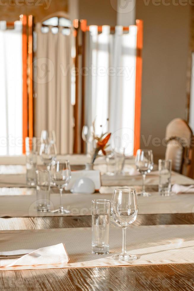 glazen, bloemenvork, mes geserveerd voor het diner in restaurant met gezellig interieur foto