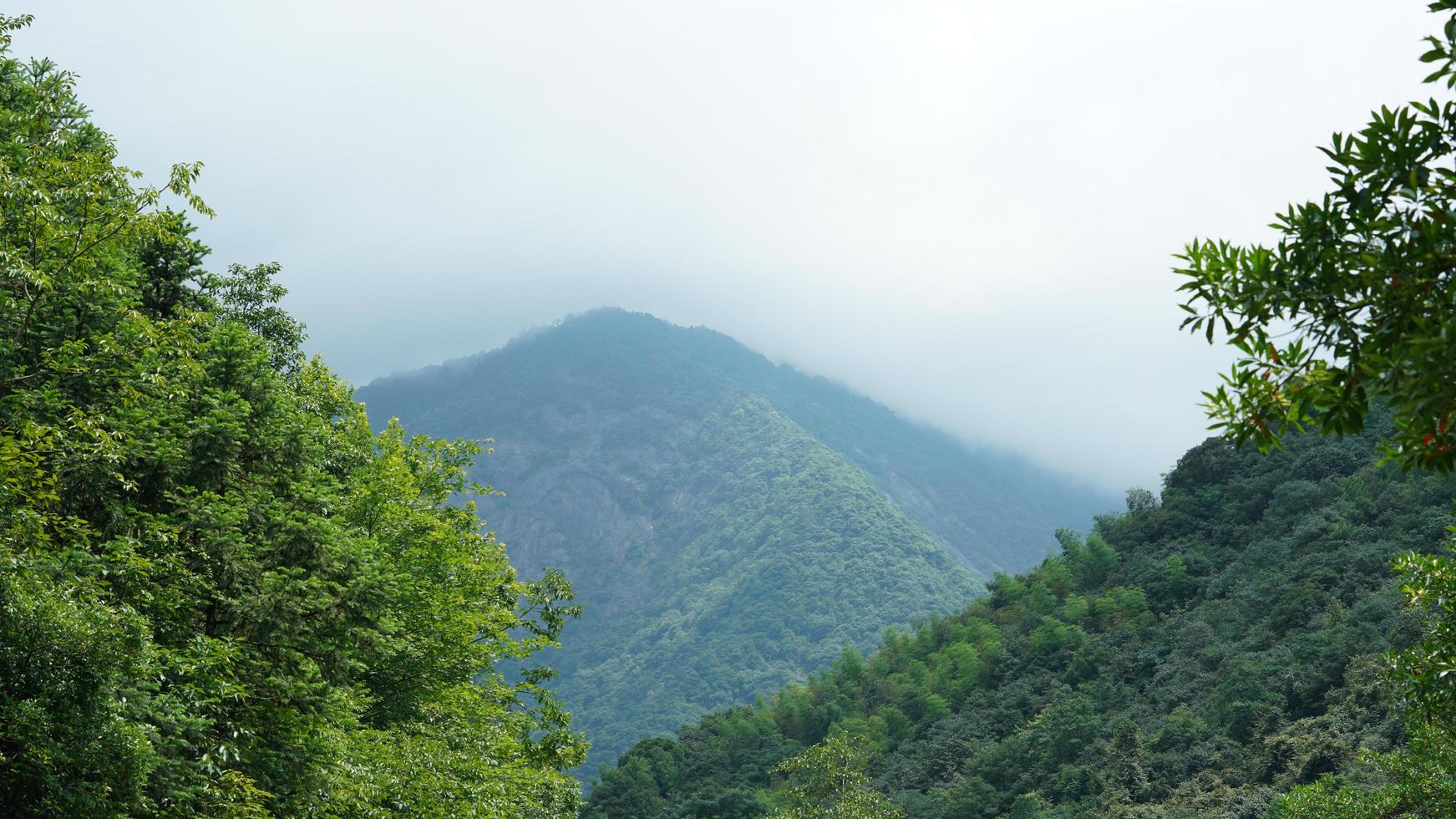 de prachtige berglandschappen met het groene bos en het kleine dorpje als achtergrond op het platteland van China foto