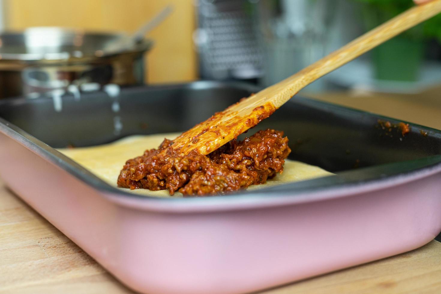 rundvlees met tomatensaus op plakken pasta zetten. bereiding van lasagne. foto