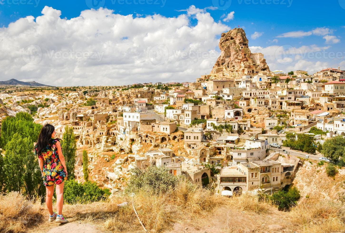 kaukasische jonge vrouw toerist op gezichtspunt staan en kijken naar ostahisar kasteel oriëntatiepunt in cappadocië. reisvakanties in turkije foto