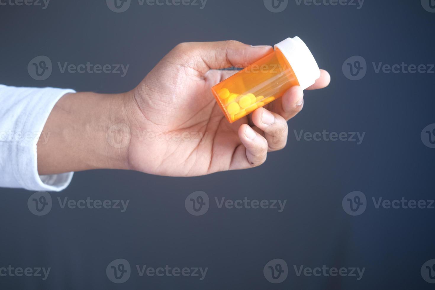 jonge man hand met medicijn pil container foto