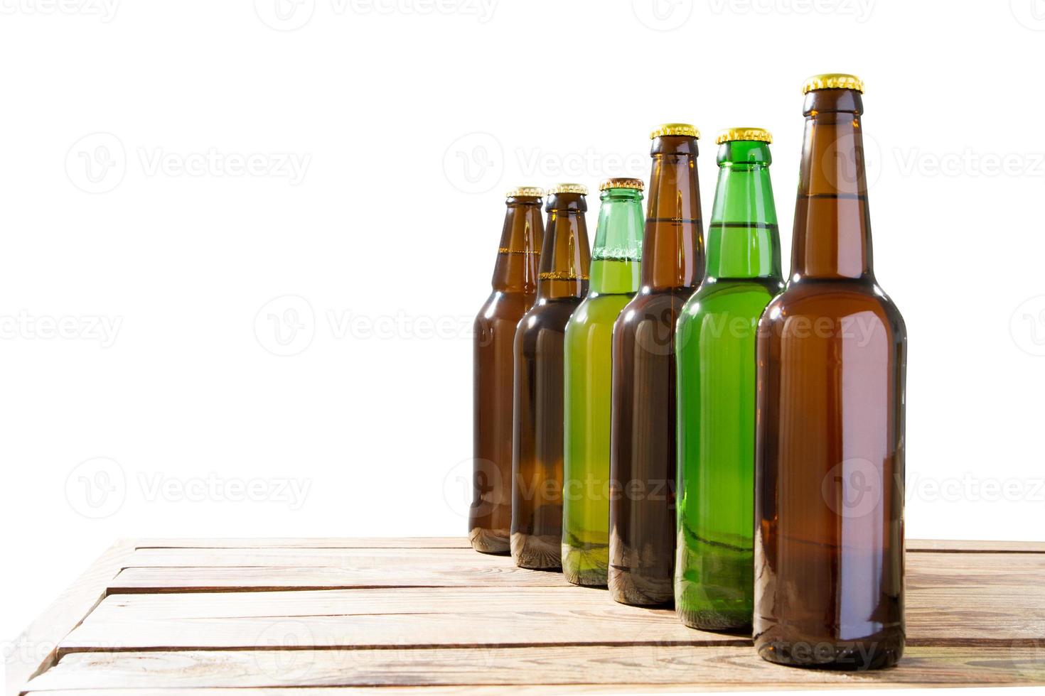 foto van zes verschillende volle bierflesjes zonder etiketten. apart uitknippad voor elke fles inbegrepen. zes 6 afzonderlijke foto's samengevoegd. bierflesjes op tafel geïsoleerde kopie ruimte