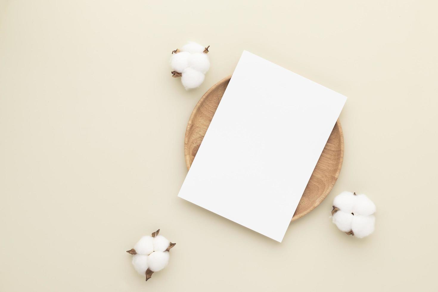 blanco papieren kaarten, mockup met een katoenen bloem op een houten plaat, beige achtergrond, minimale beige werkpleksamenstelling, plat gelegd, mockup foto