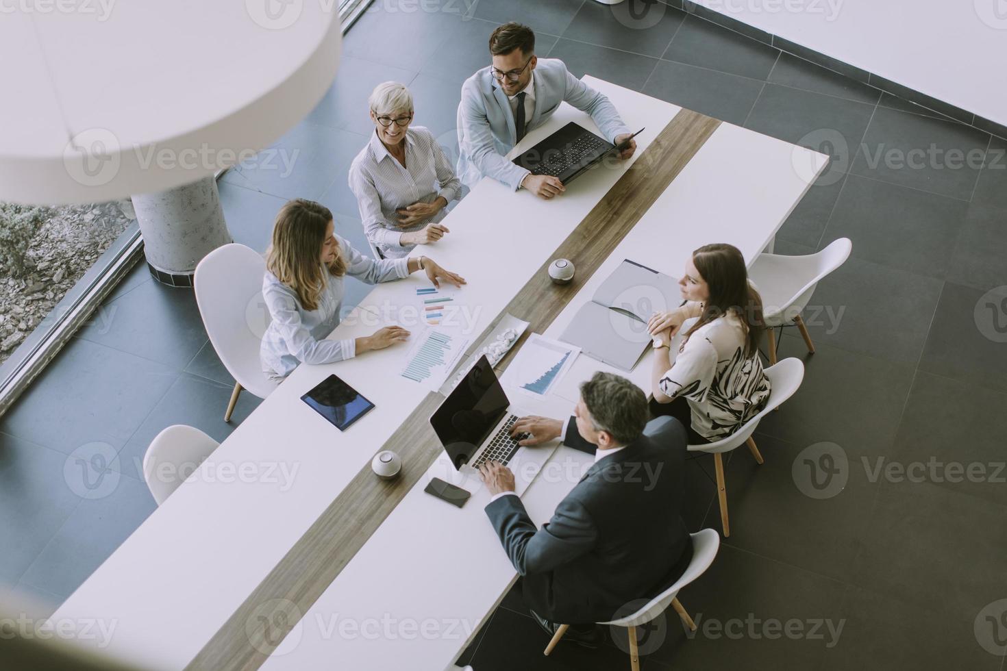 luchtfoto bij een groep zakenmensen die samenwerken en een nieuw project voorbereiden op een vergadering op kantoor foto