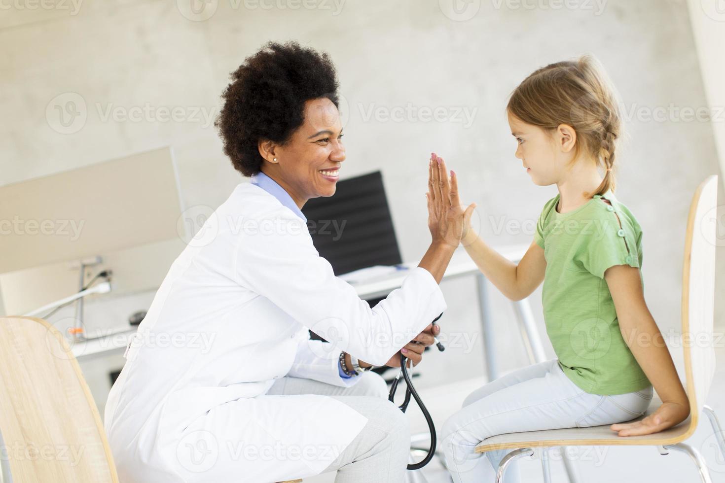 schattig klein meisje bij het kinderarts onderzoek foto