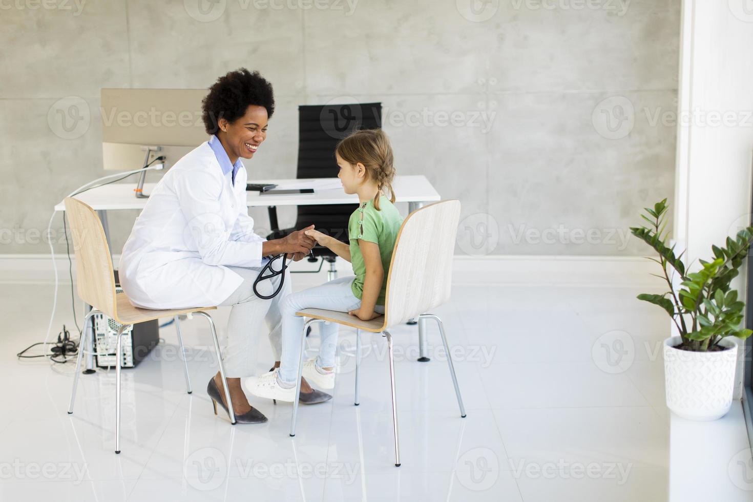 schattig klein meisje bij het kinderarts onderzoek foto