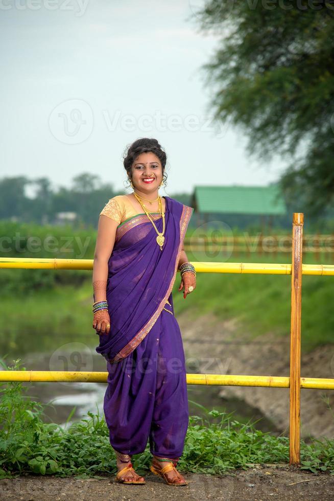 mooi Indisch jong meisje in traditionele saree die buitenshuis poseert foto