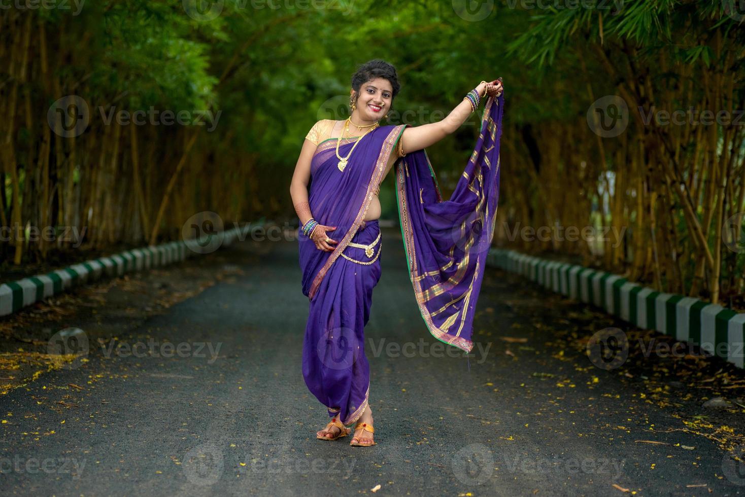 Indiase traditionele mooie jonge meid in saree poseren buitenshuis foto