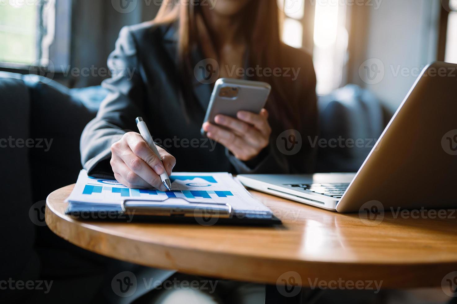 vrouwen tellen munten op rekenmachine uit het spaarvarken. hand met pen bezig met rekenmachine om op bureau te berekenen over de kosten op kantoor aan huis. foto