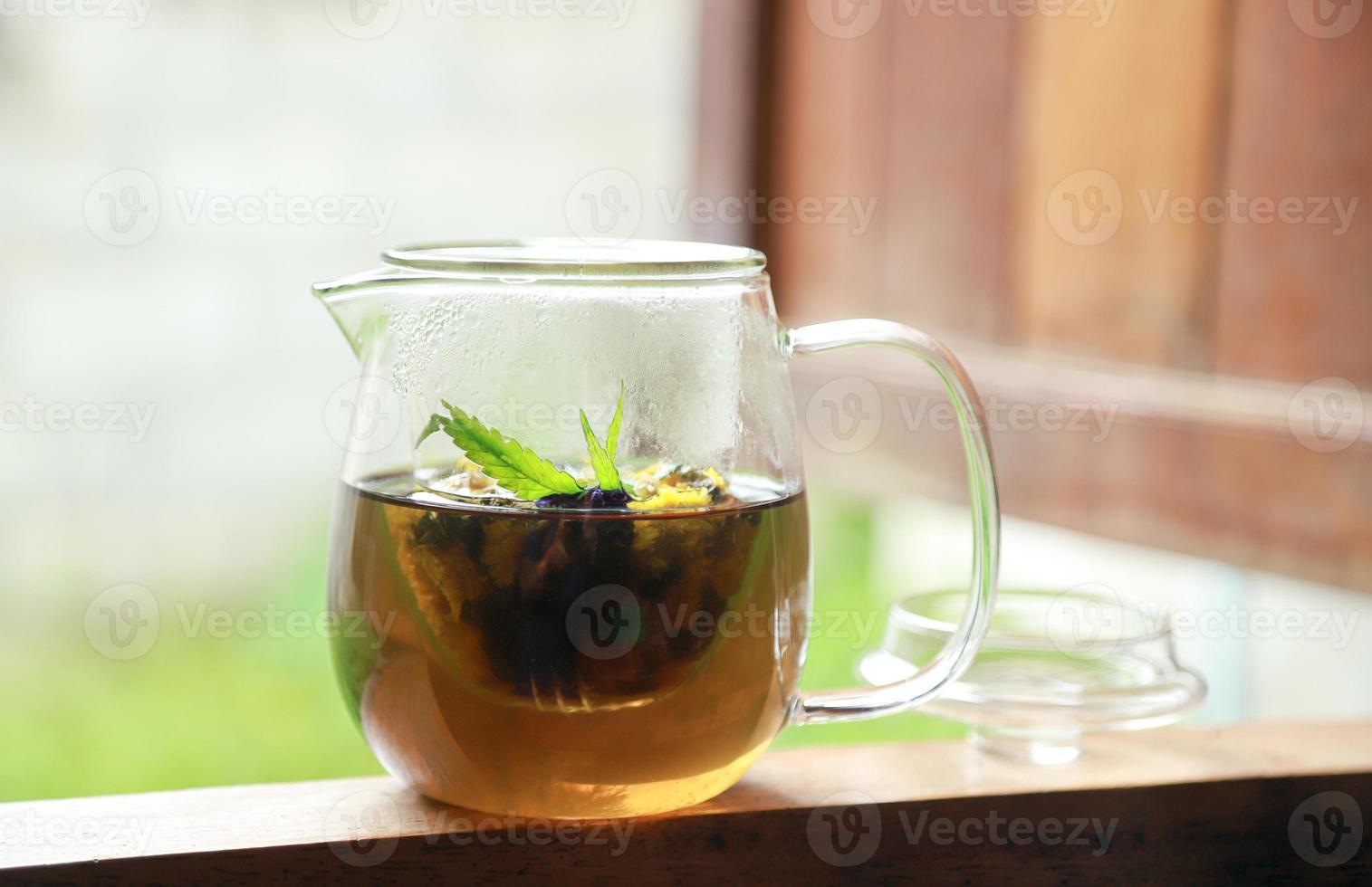 bloementhee in glazen pot met cannabisblad voor gezond aroma drinken foto