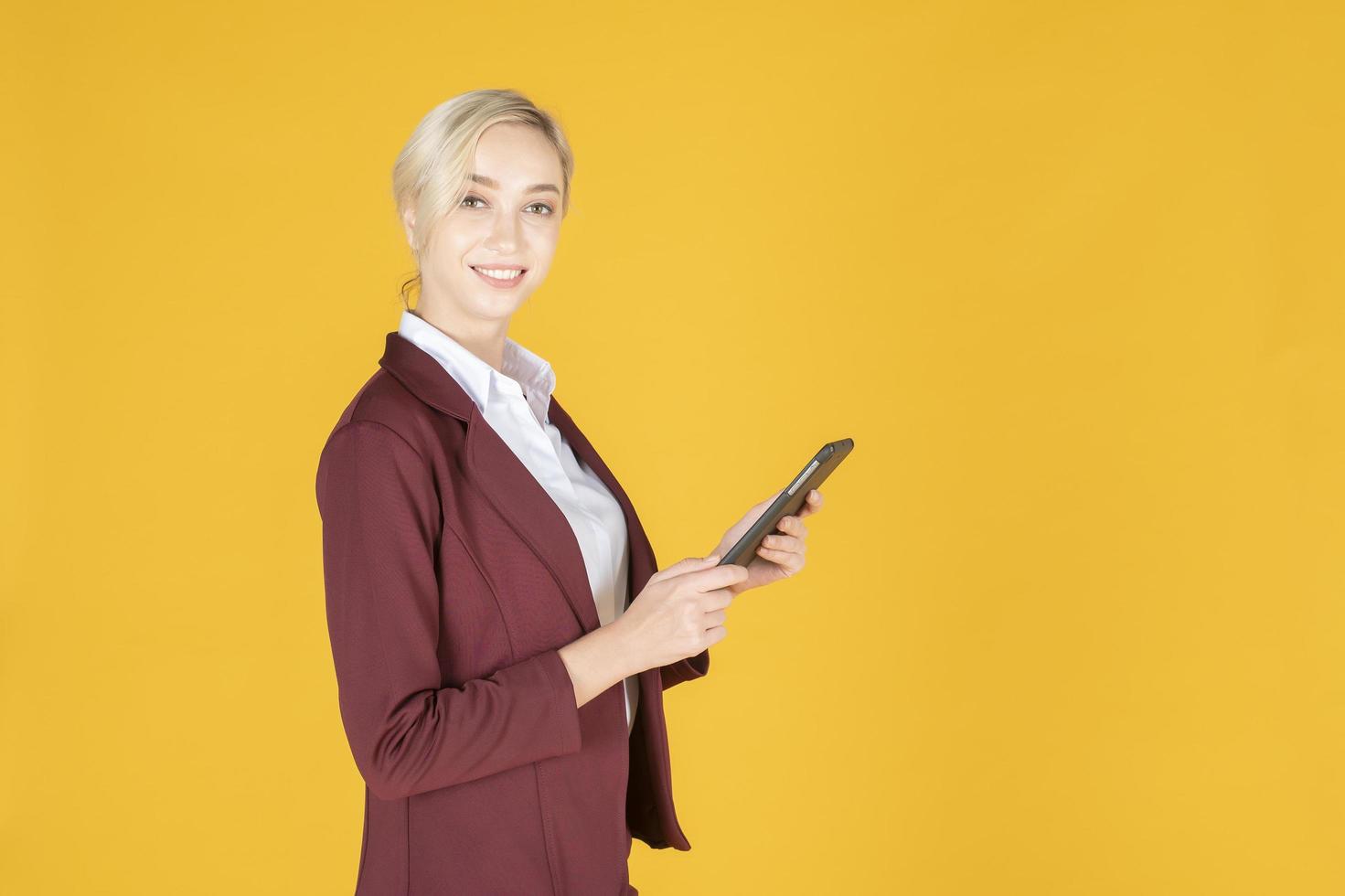 zakenvrouw gebruikt tablet in studio gele achtergrond foto