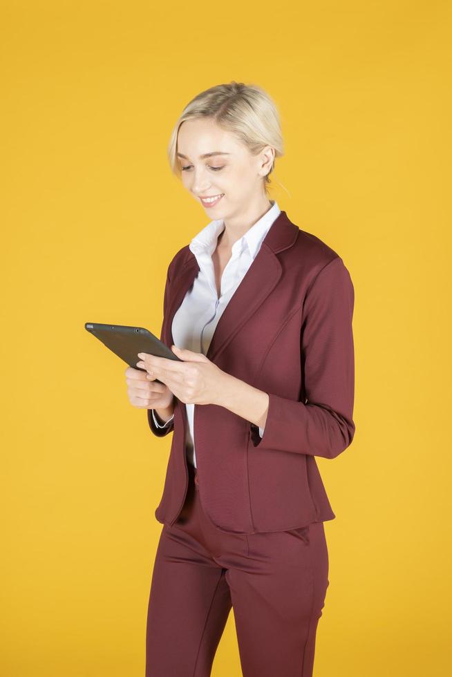 zakenvrouw gebruikt tablet in studio gele achtergrond foto