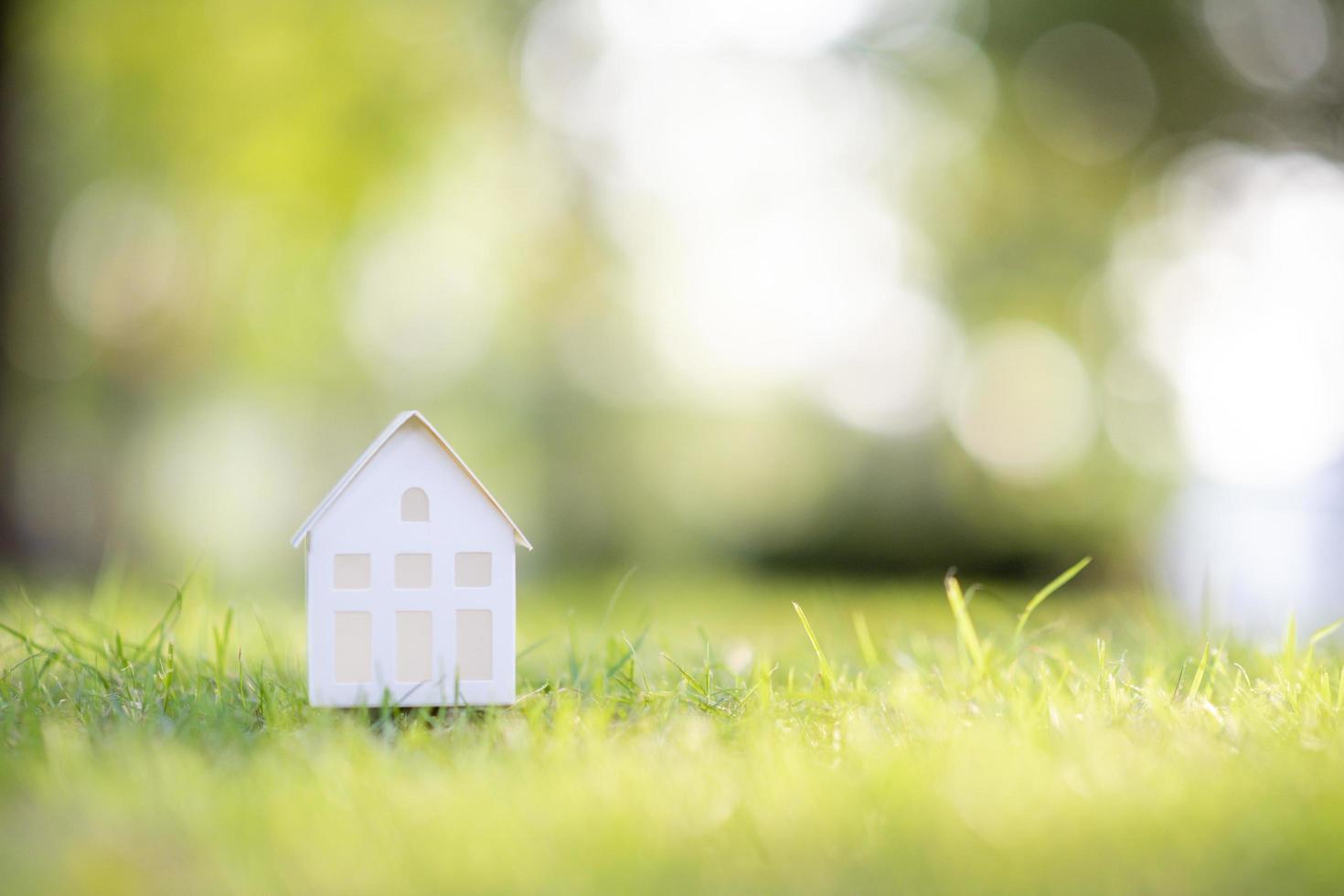 klein wit huis op groene achtergrond foto