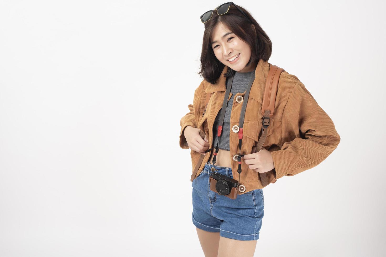 mooie jonge aziatische toeristenvrouw gelukkig op witte studio als achtergrond foto