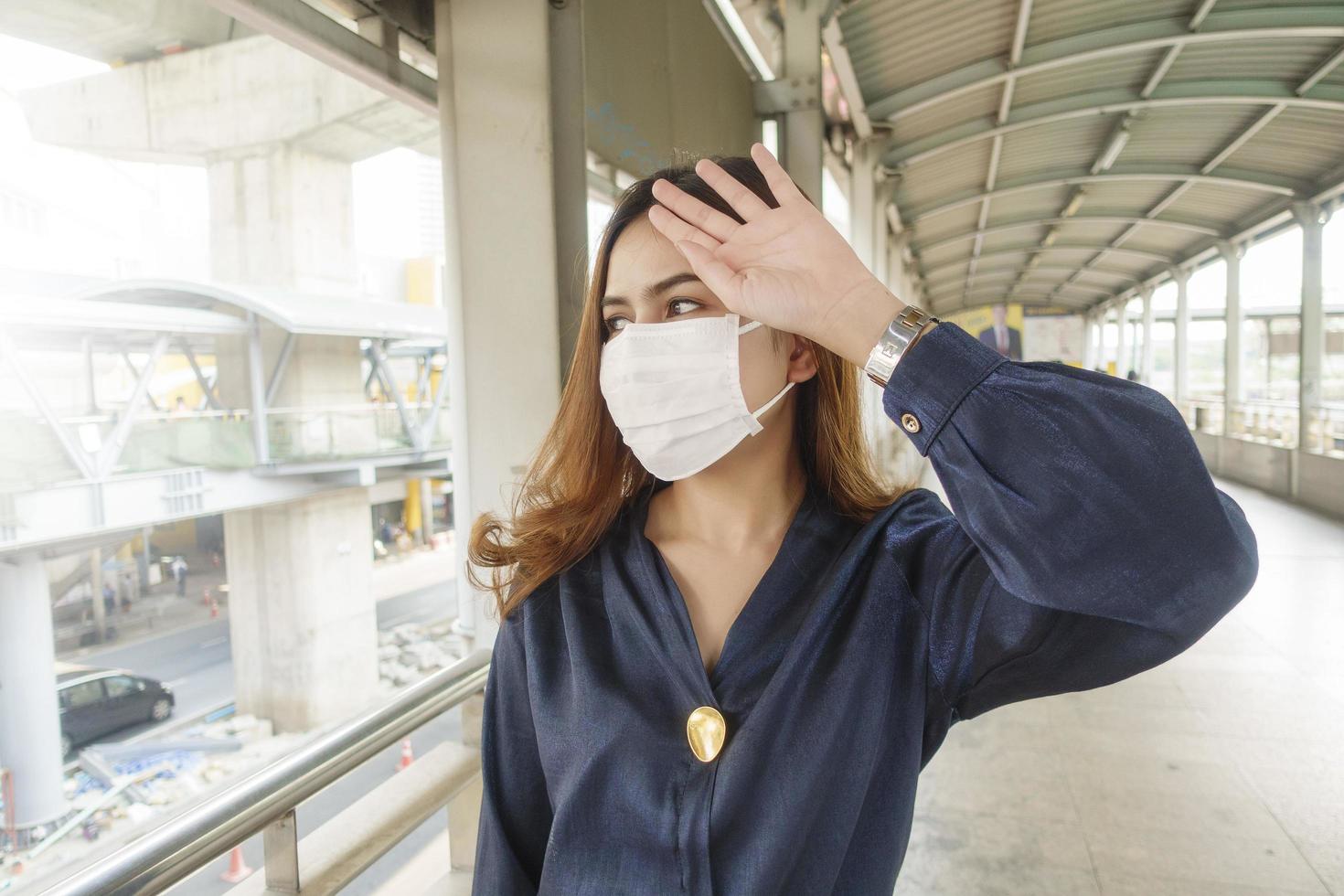 mooie vrouw die een antistofmasker draagt, beschermt luchtvervuiling en pm 2.5 op straatstad foto
