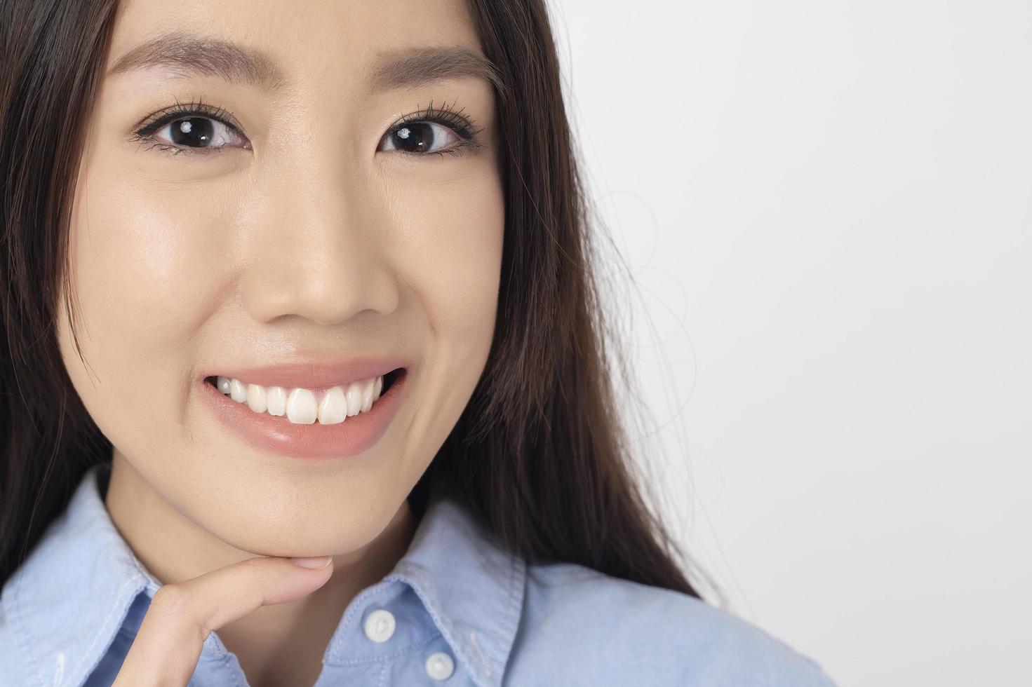 close-up van aziatische vrouw met mooie tanden op witte achtergrond foto