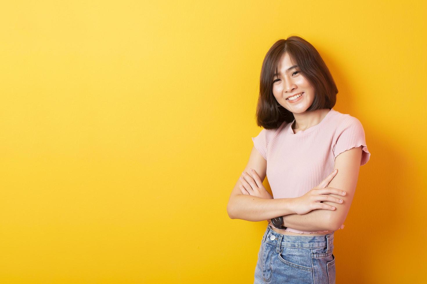 mooie Aziatische vrouw universiteitsstudent gelukkig op gele achtergrond foto