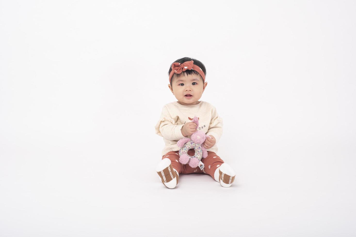 schattig Aziatisch babymeisje is portret op witte achtergrond foto