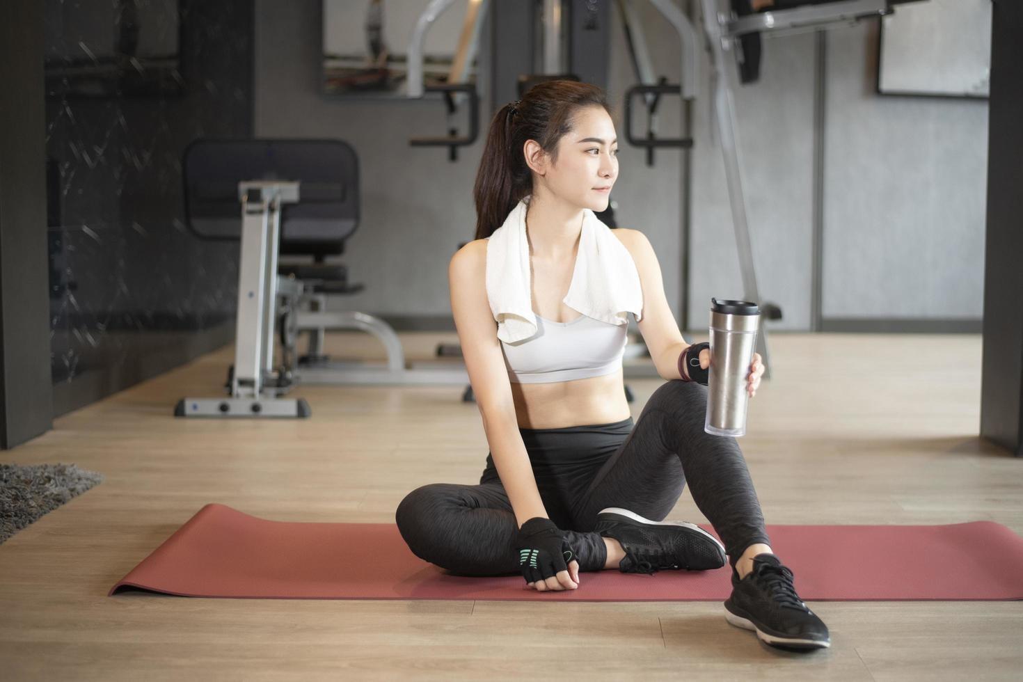 mooie aziatische vrouw doet oefening in de sportschool foto