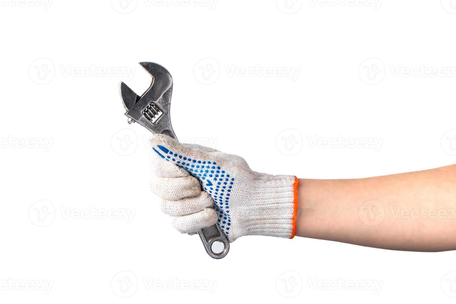 man in witte werkhandschoenen houdt moersleutel vast. foto