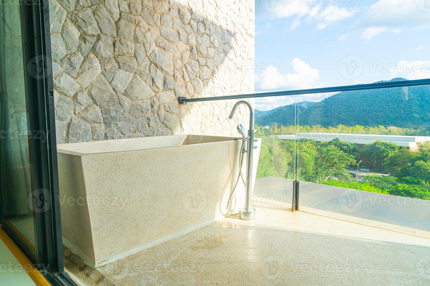 badkuip op balkon met bergheuvelachtergrond foto