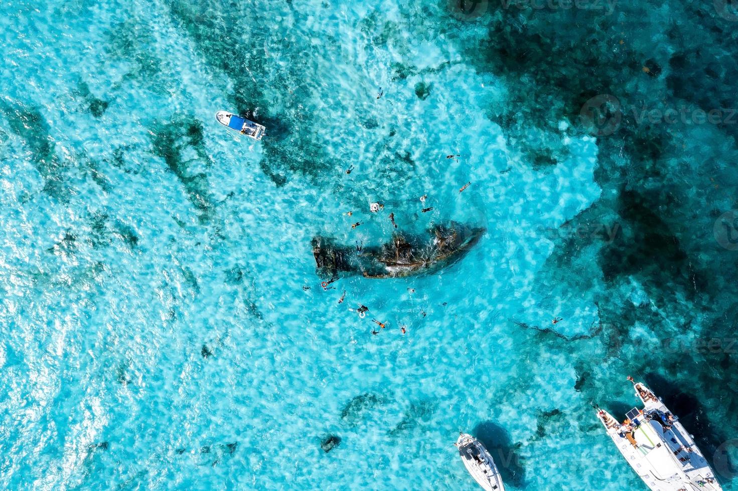 mensen snorkelen rond het scheepswrak in de buurt van bahama's in de caribische zee. foto