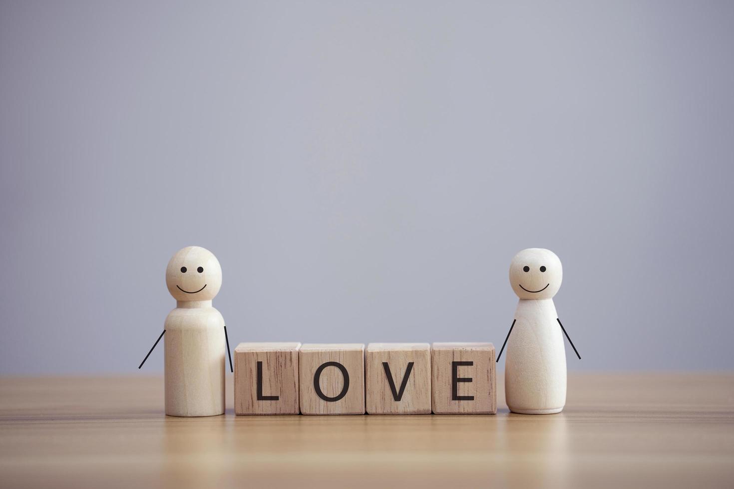 gelukkig hout familie persoon model een smiley met woord liefde op houten kubus tafel achtergrond foto