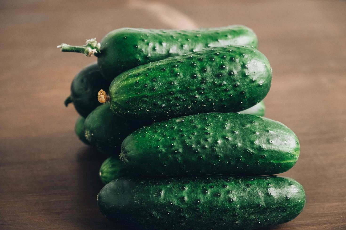 verse groene komkommers op een houten tafel achtergrond. kopiëren, lege ruimte voor tekst foto