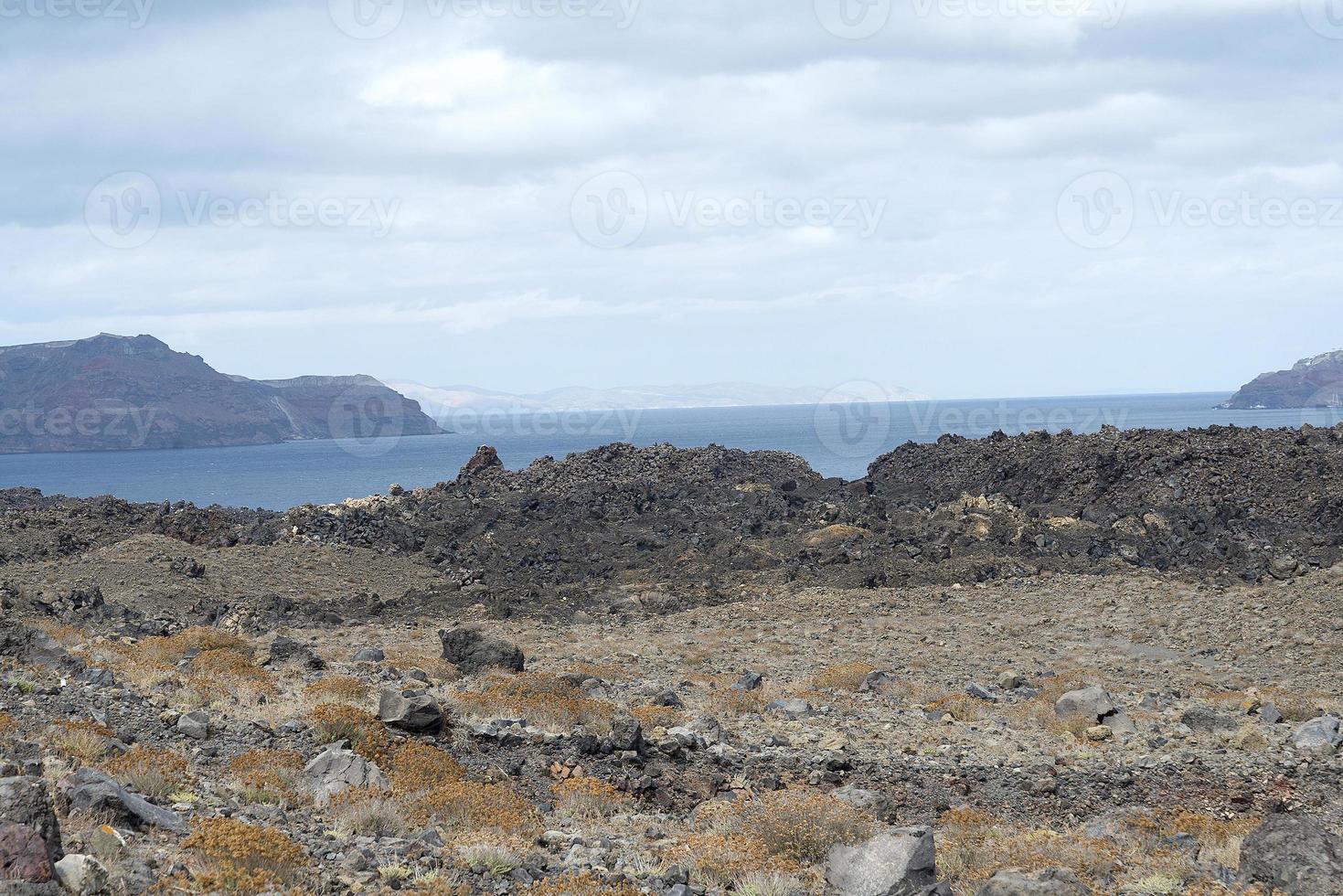 exotische rotsachtige weg naar de krater van de vulkaan. de vulkaan bevindt zich in de beroemde caldera van santorini. foto