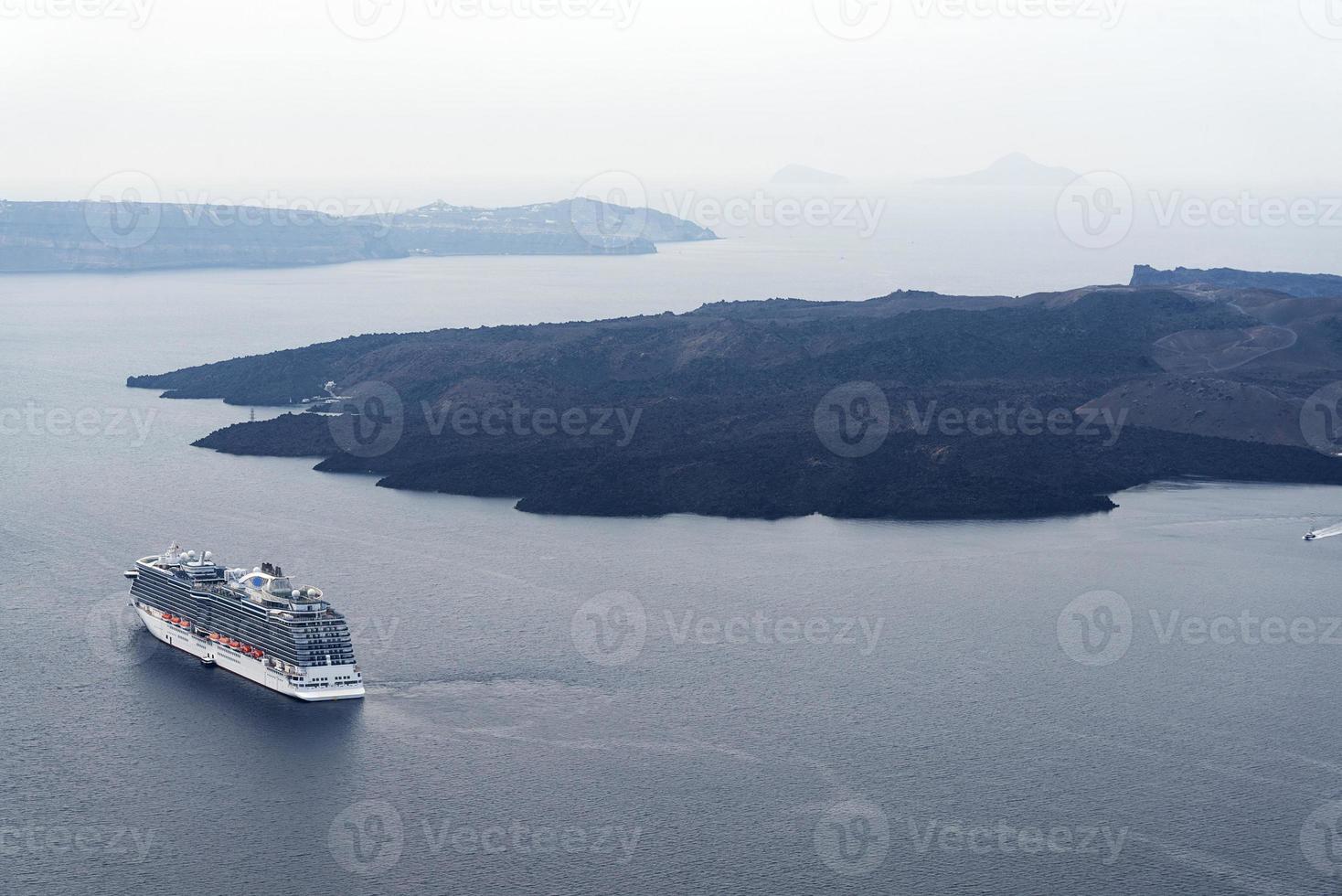 prachtig landschap met uitzicht op zee. cruiseschip in zee bij nea kameni, een klein grieks eiland in de egeïsche zee bij santorini. foto