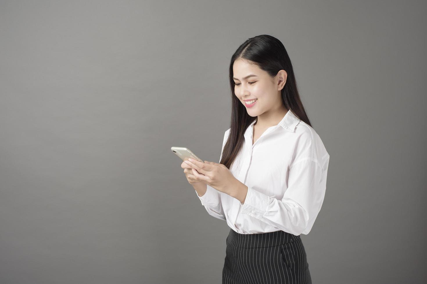 mooie vrouw gebruikt mobiele telefoon in studio foto