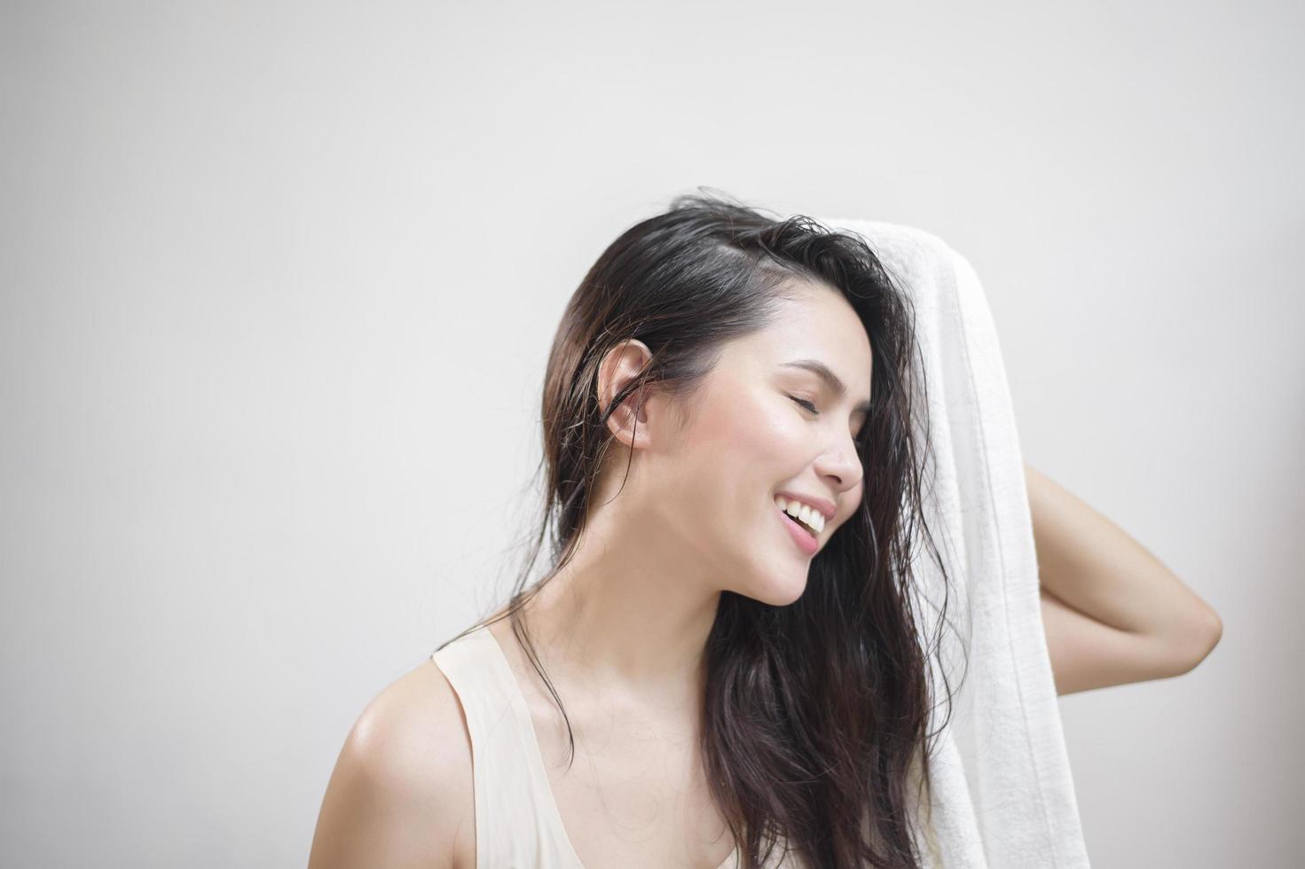 een vrouw droogt haar haar met een handdoek na het douchen foto