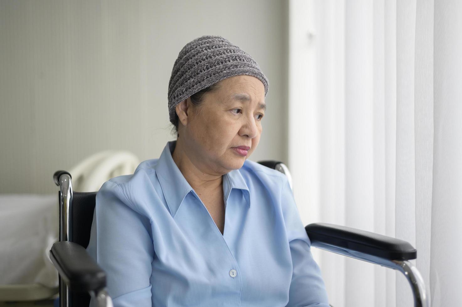 depressieve en hopeloze Aziatische kankerpatiënt vrouw met hoofddoek in het ziekenhuis. foto